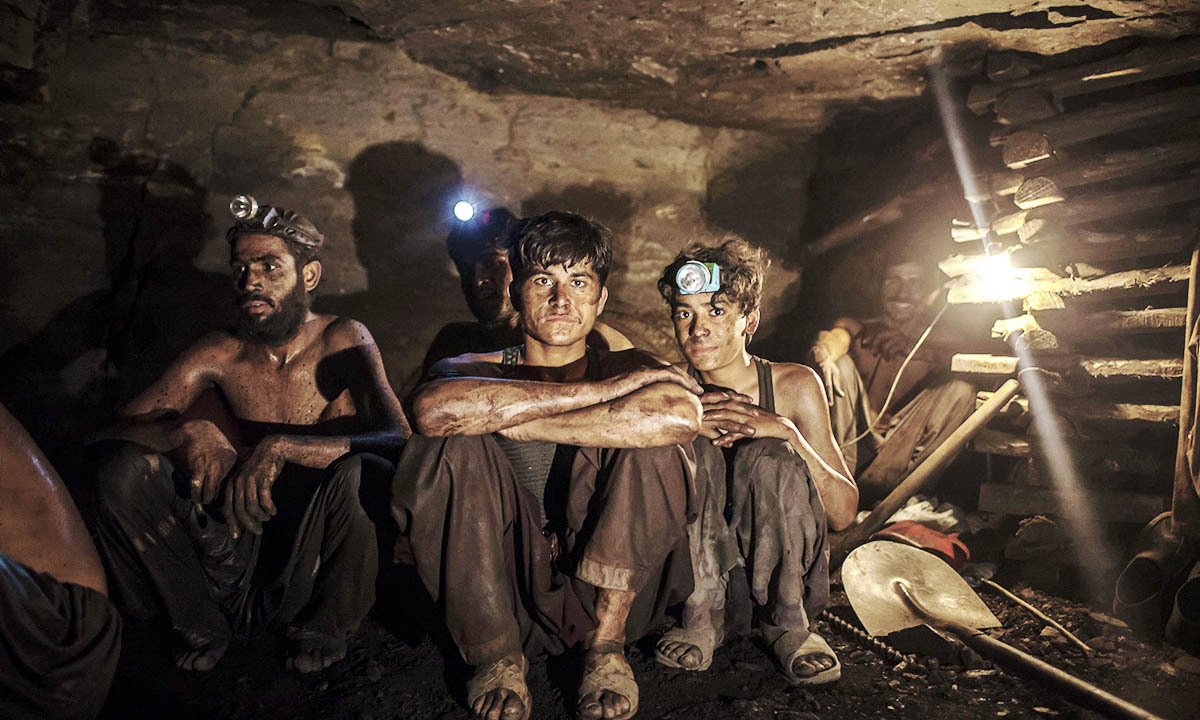 Miners pose for a photograph at the coal face inside a mine in Choa Saidan Shah, Punjab province
