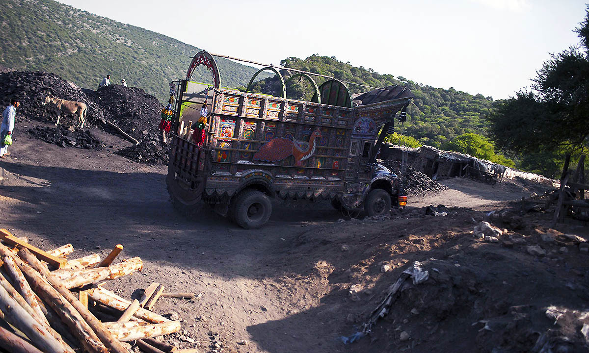 A truck drives past a coal field in Choa Saidan Shah, Punjab province